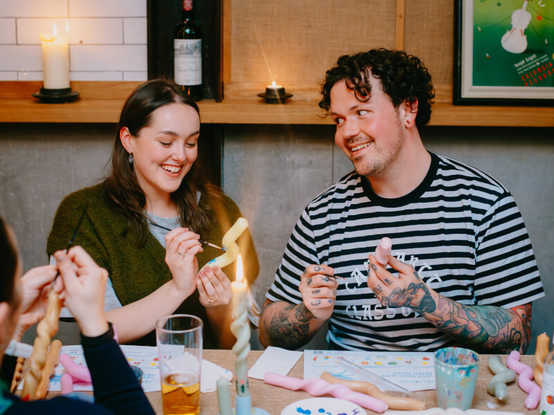 Two people at a candle painting class